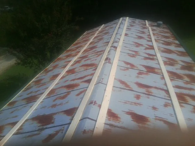 Rusted metal roof panels with new wood purlins before replacement — Storm Damage Roof Repair in Everett by Roofing Brothers